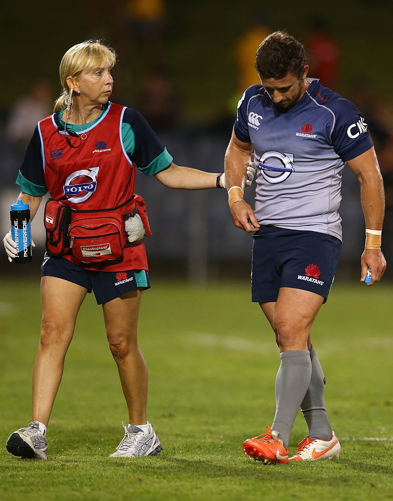 Sharron Flahive walks with Brendan McKibben in a Waratahs preseason match in 2015. Photo: Getty...