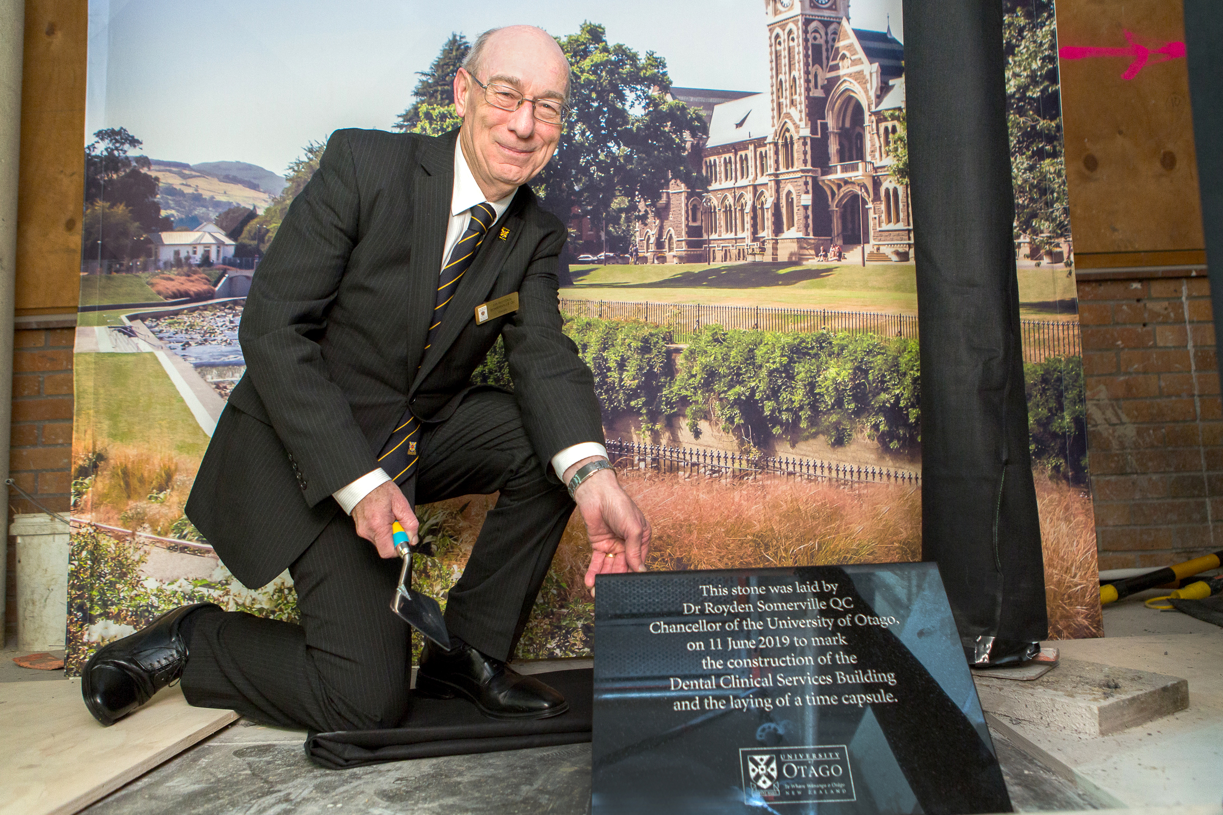 University Chancellor Dr Royden Somerville places the stone plaque to commemorate the opening of...