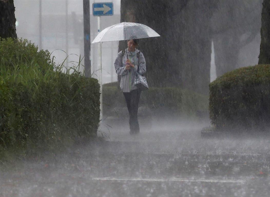 A woman walks through heavy rain in Kirishima, Kagoshima Prefecture, on Wednesday. Photo: Kyodo...