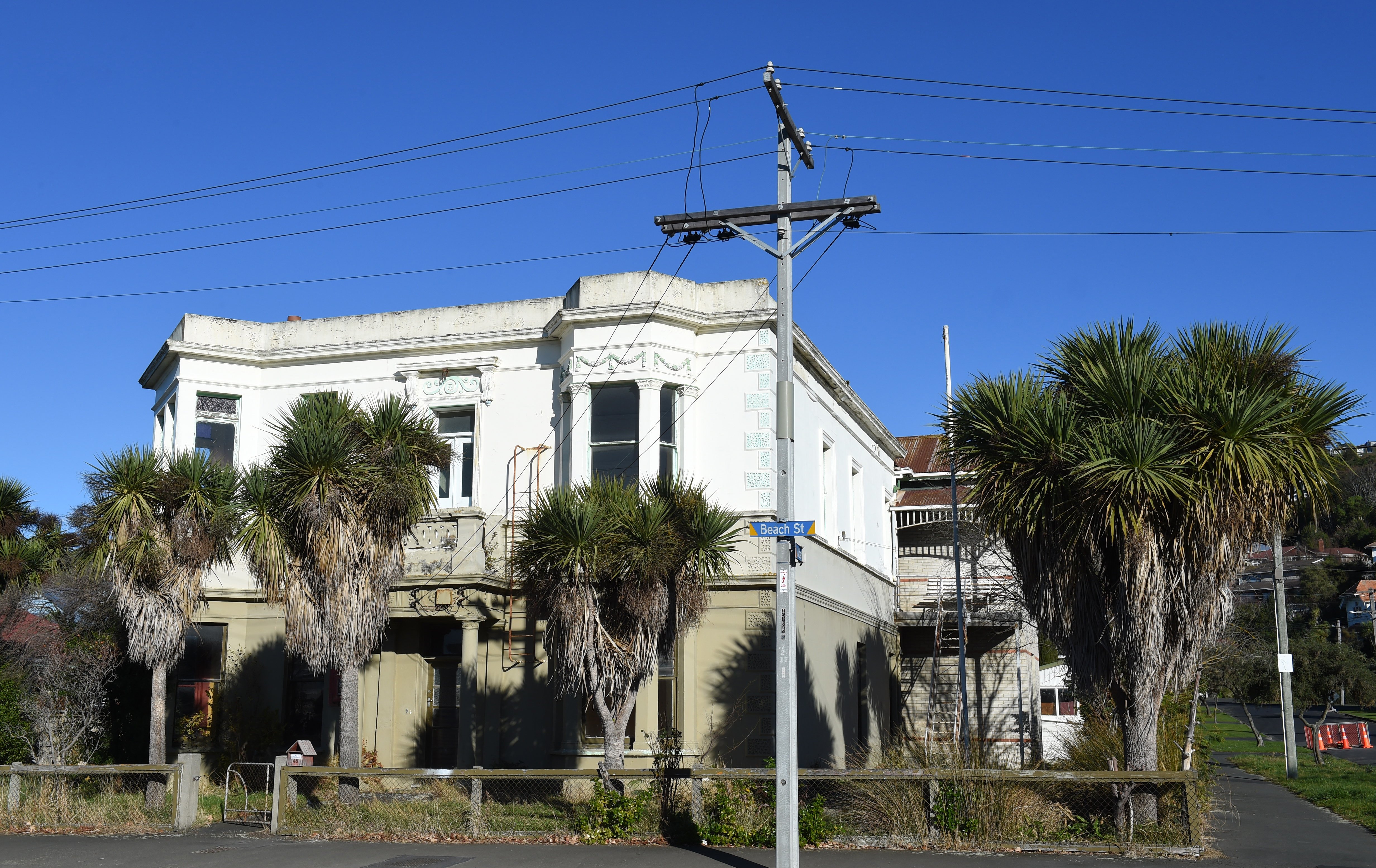 Cabbage trees/ti kouka give this property in Beach St, St Clair in interesting Spanish-American...