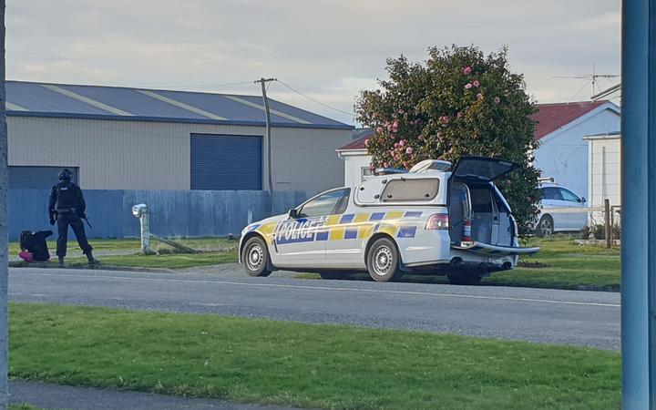 Armed police officers stand guard outside a home in Surrey Street, Gore. Photo: RNZ/ Tim Brown