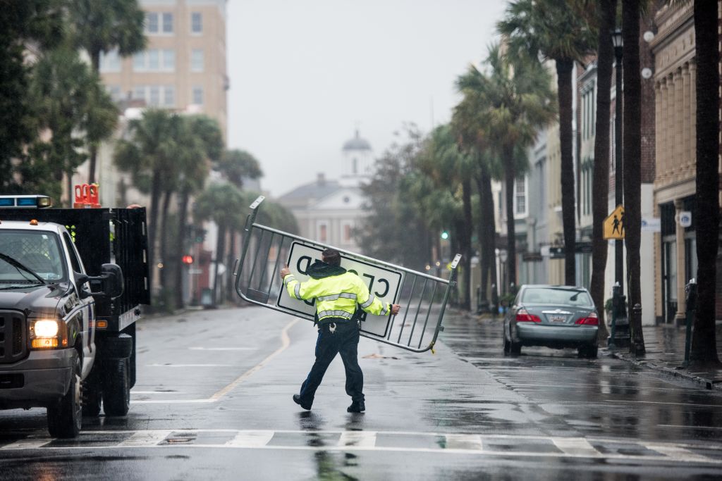 A police officer moves a traffic barrier amid wild weather in Charleston, South Carolina. Photo:...