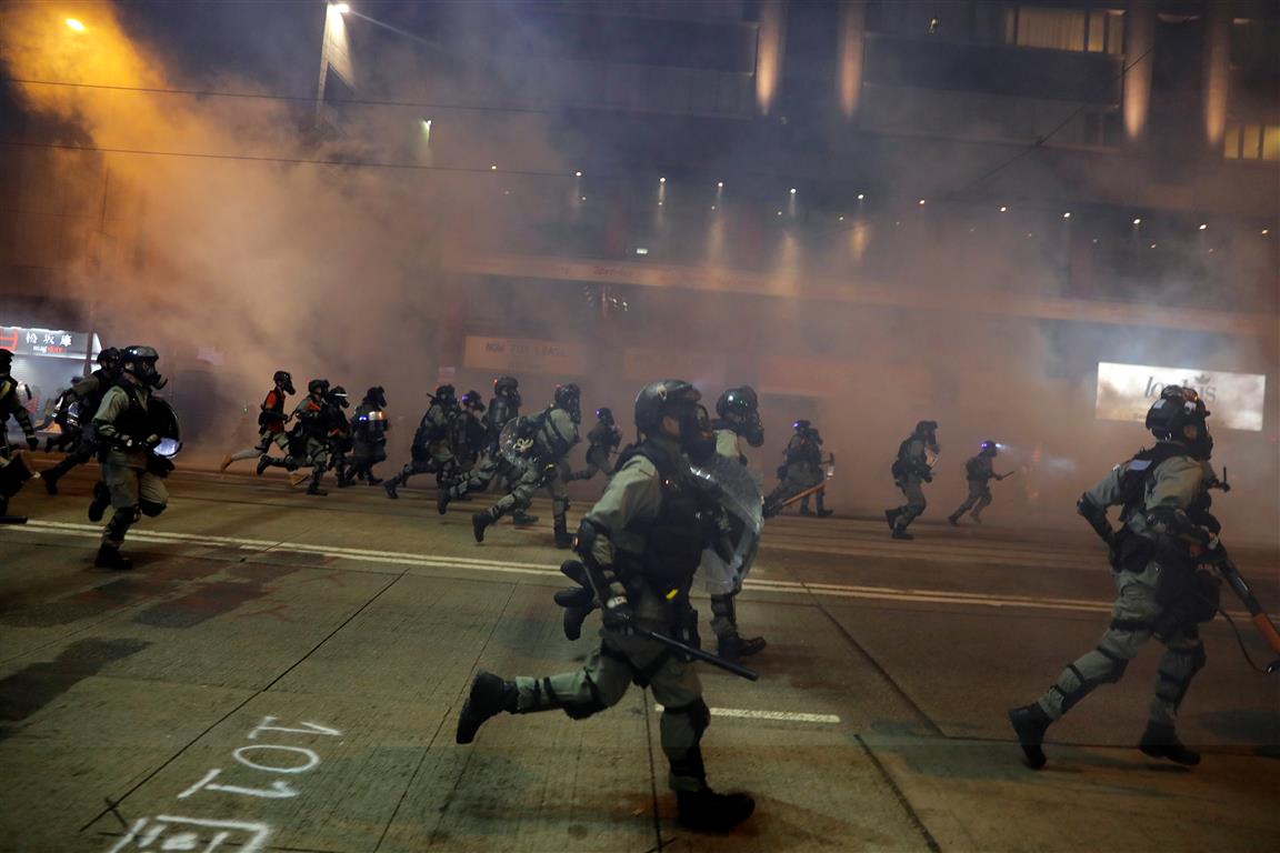 Riot police chase away protesters near Causeway Bay metro station, after leader Carrie Lam...