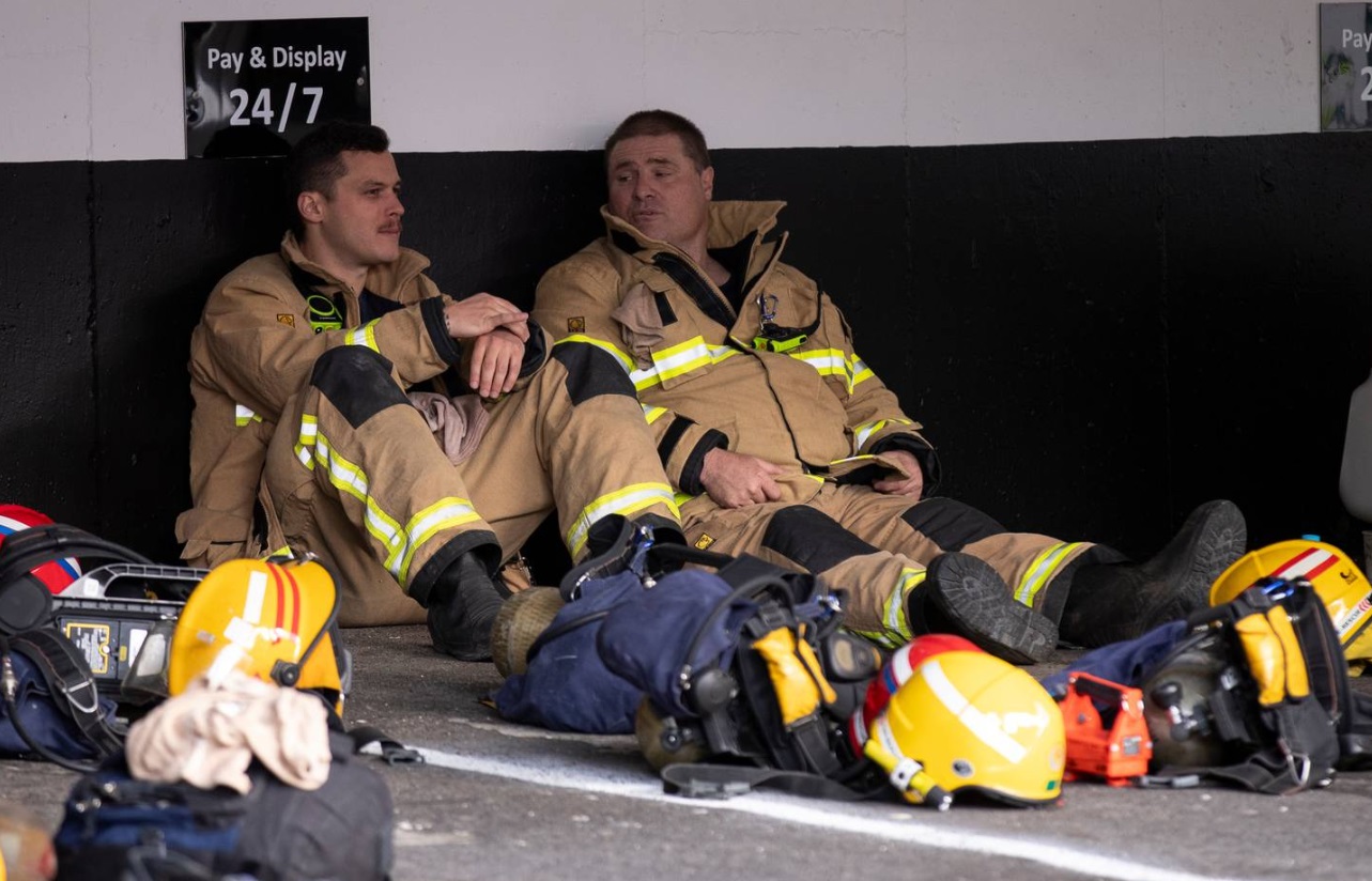 Firefighters take a break from battling the blaze. Photo: NZ Herald