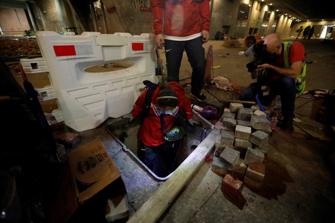 A protester tries to escape through a sewage tunnel inside the Hong Kong Polytechnic University...