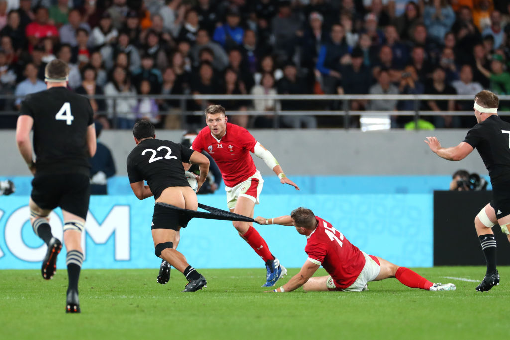 New Zealand's Anton Lienert-Brown tries to break away from Wales' Hallam Amos. Photo: Getty