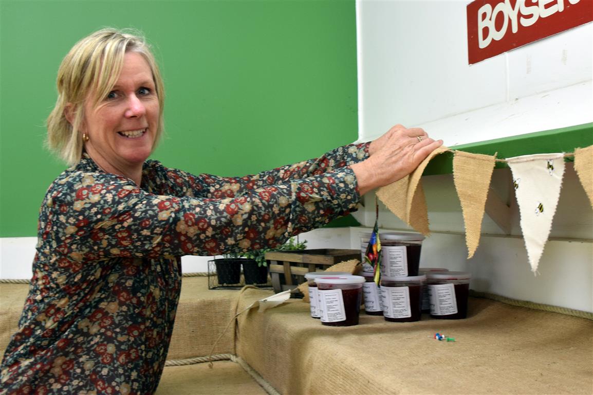McArthur’s Berry Farm co-owner Kaye McArthur hangs bunting in preparation for her shop in Outram...