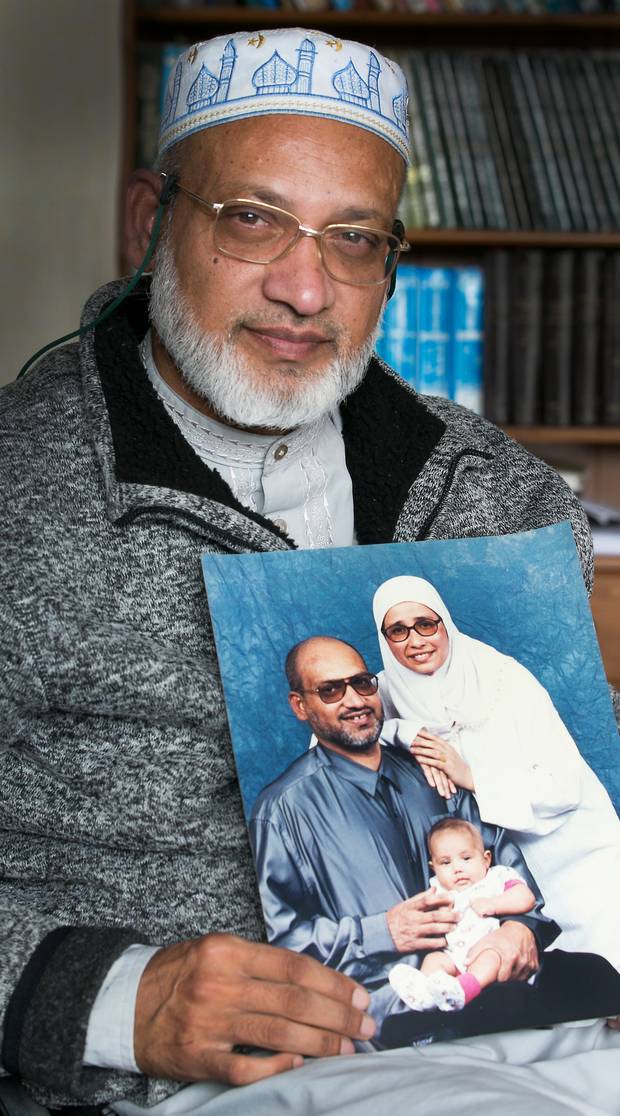 Farid Ahmed holding a photograph of his family, including his wife Husna Ahmed who was killed in...