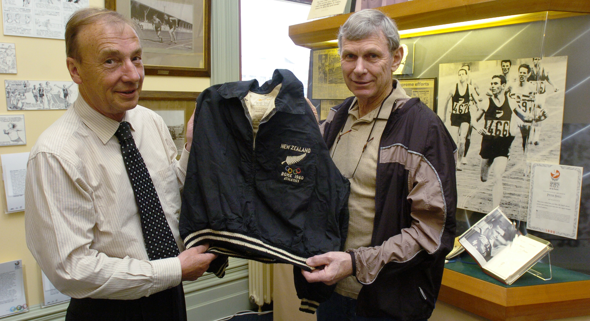 New Zealand Sports Hall of Fame chief executive Ron Palenski (left) accepts the tracksuit top...
