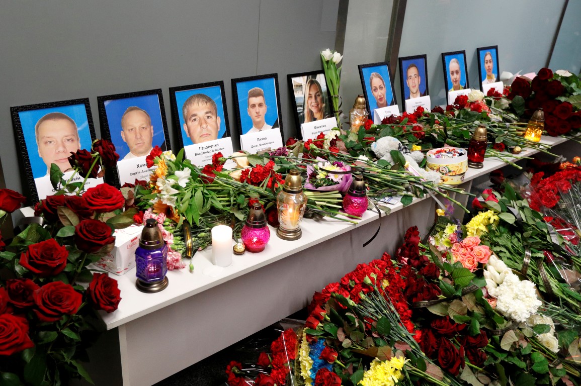 Tributes sit in front of pictures of the flight crew members of the crashed plane, at the...