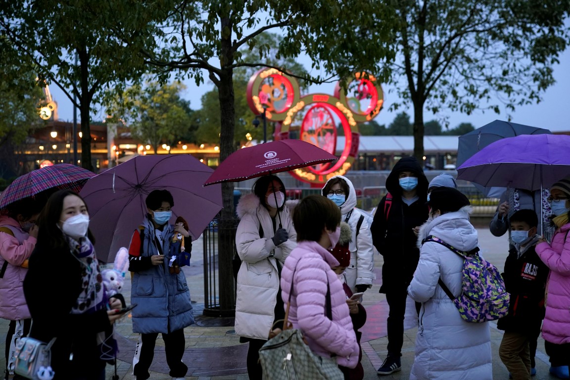 Visitors wearing masks outside the Shanghai Disney Resort, which will be closed during the...