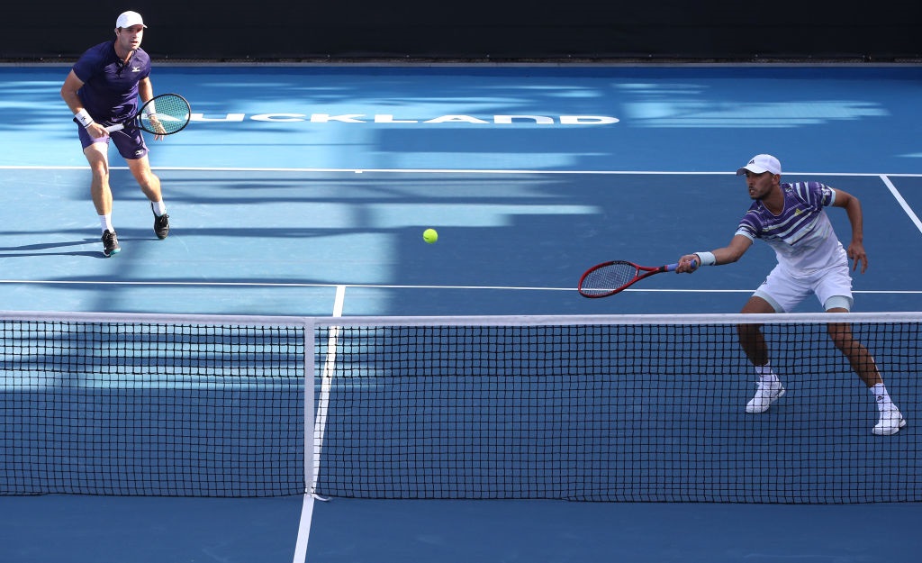 Ben McLachlan plays a shot as Luke Bambridge watches on during their first round win in the men's...