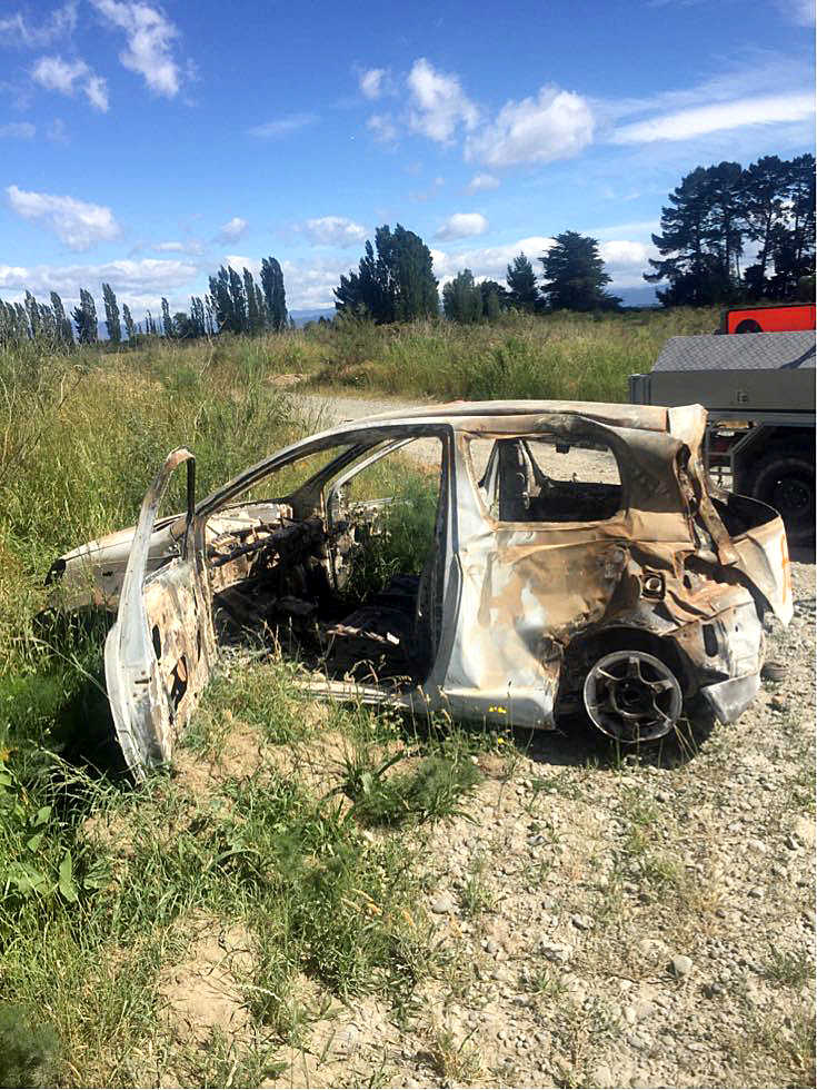 Burnt-out cars like this one being dumped along the Waimakariri River could be a fire risk. Photo...