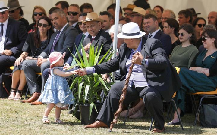 Prime Minister Jacinda Ardern's daughter Neve Te Aroha Gayford plays at the feet of those sitting...