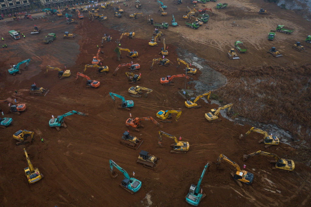 Workers driving excavators at the construction site of a new field hospital in Wuhan. Photo: Getty