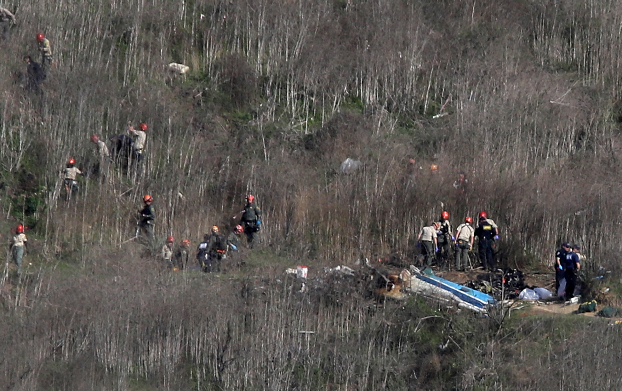 Investigators work at the scene of the helicopter crash which killed NBA star Kobe Bryant in...