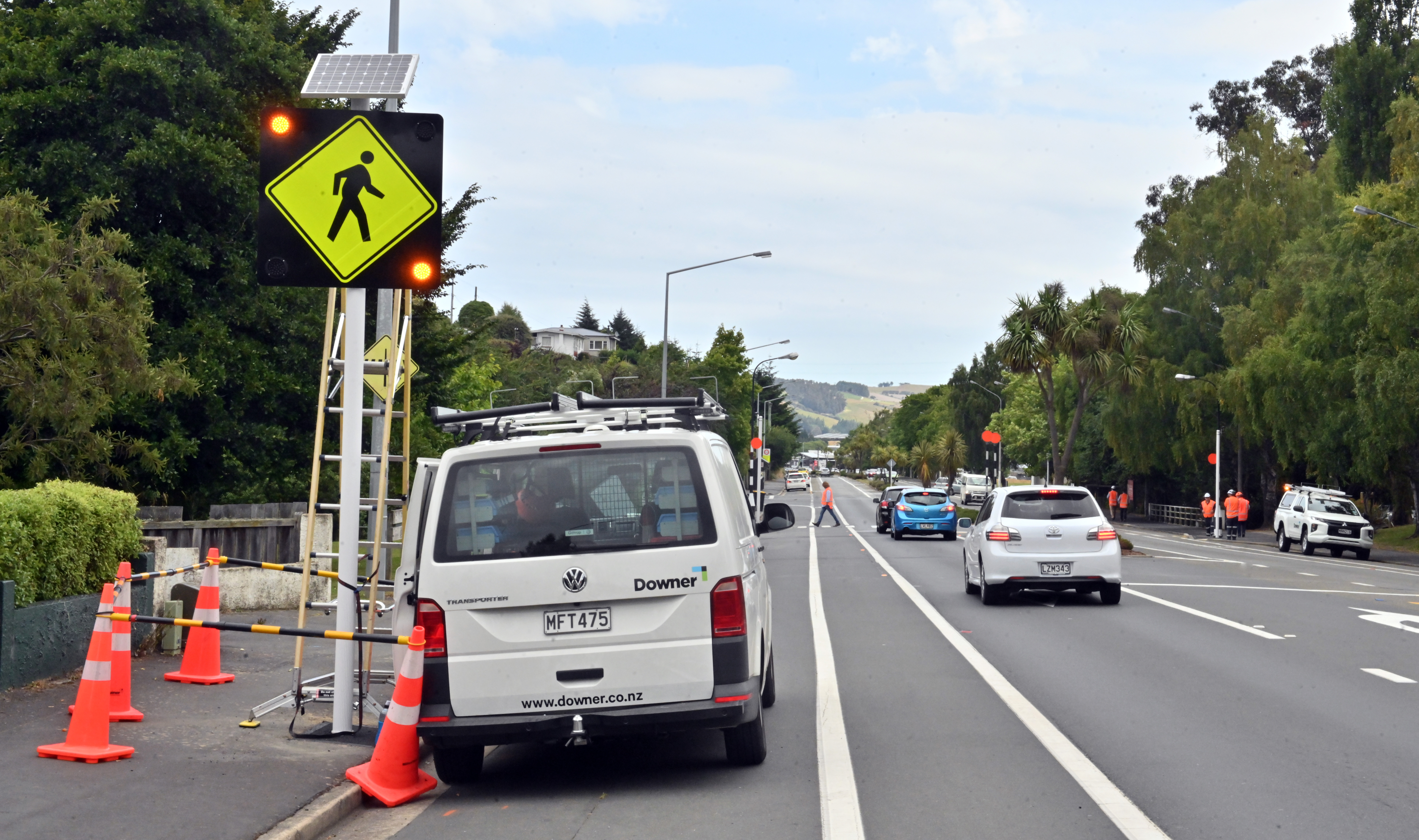 Downer staff complete testing of a smart crossing safety improvement system outside Kaikorai Valley College yesterday. Photo: Linda Robertson