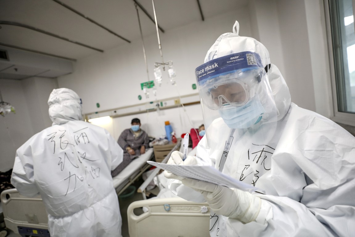 A medical worker in a protective suit checks a patient's records at Jinyintan hospital in Wuhan....