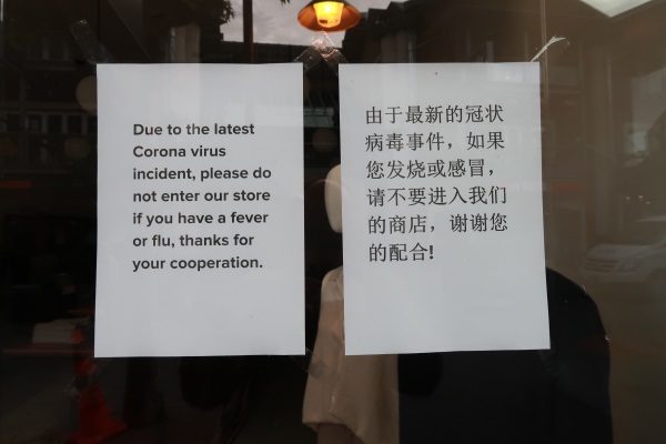 This sign on retailer Elle + Riley's Queenstown CBD store asks people, in both English and...