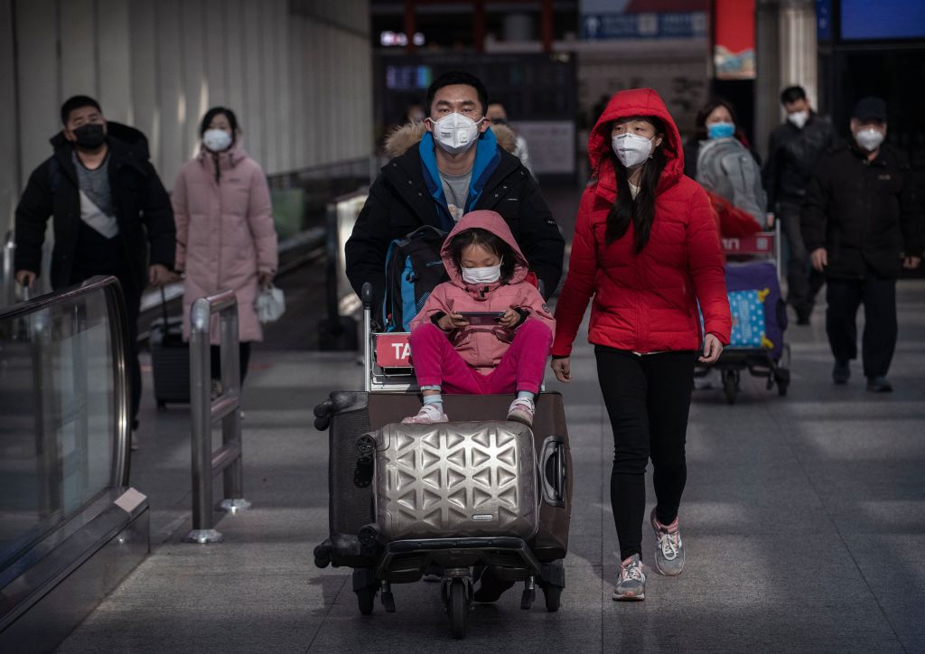 Mask-wearing travellers at Beijing Capital Airport. Photo: Getty