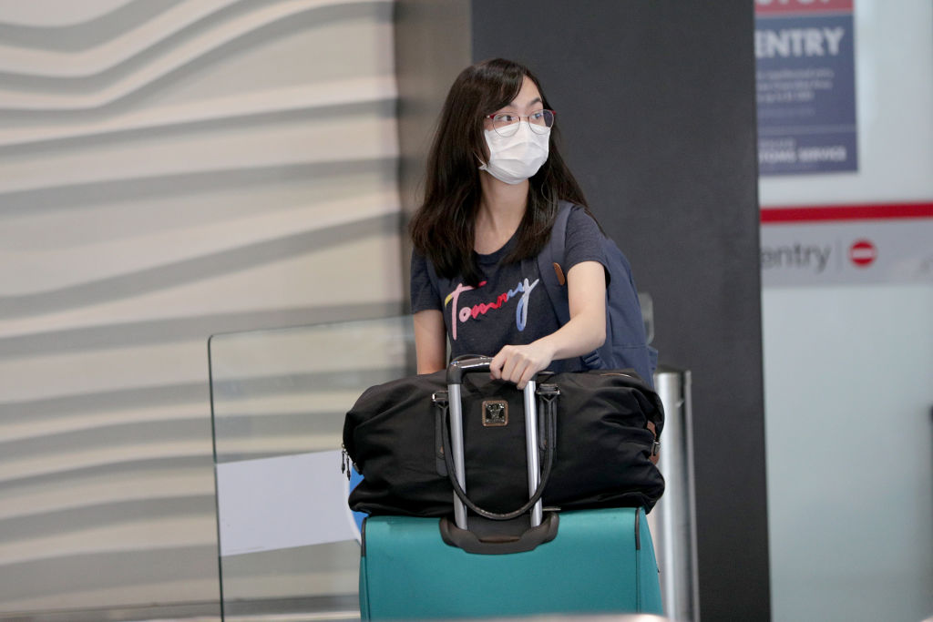 A traveller wears a protective mask in the international arrivals area at Auckland Airport last...