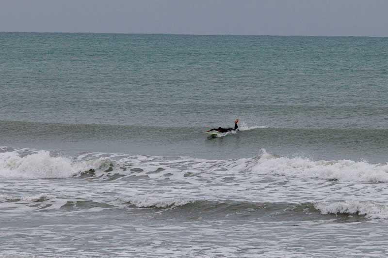 One of four surfers at Waimairi Beach defying the conditions.