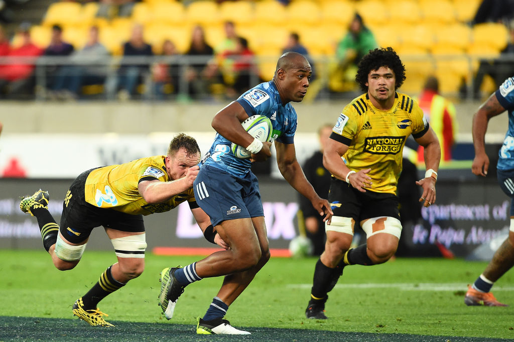 Mark Telea of the Blues makes a break against the Hurricanes. Photo: Getty