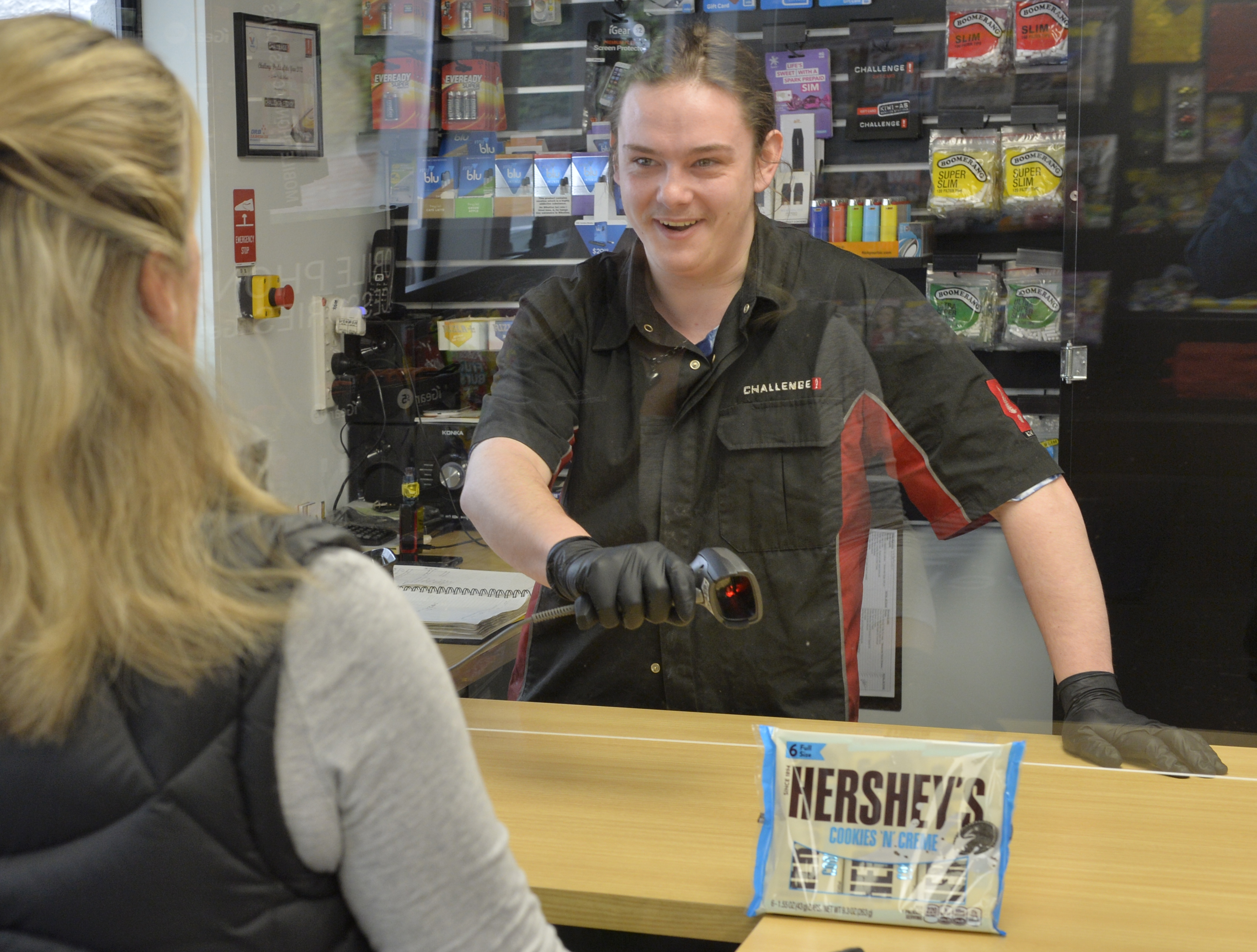 Callum Macarthur serves another customer at the Challenge Fitzroy service station yesterday under...