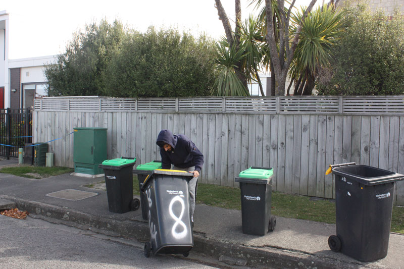 Picking up an overturned wheelie bin from the gutter on Rex St, Riccarton.