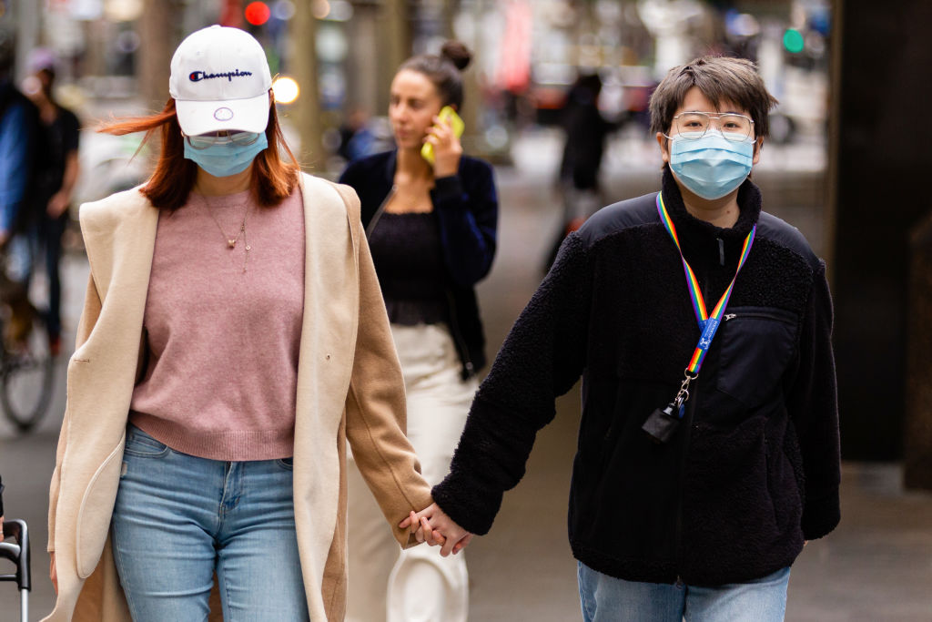 People wearing face masks walk along Swanston St in Melbourne, as more retail stores reopen their...