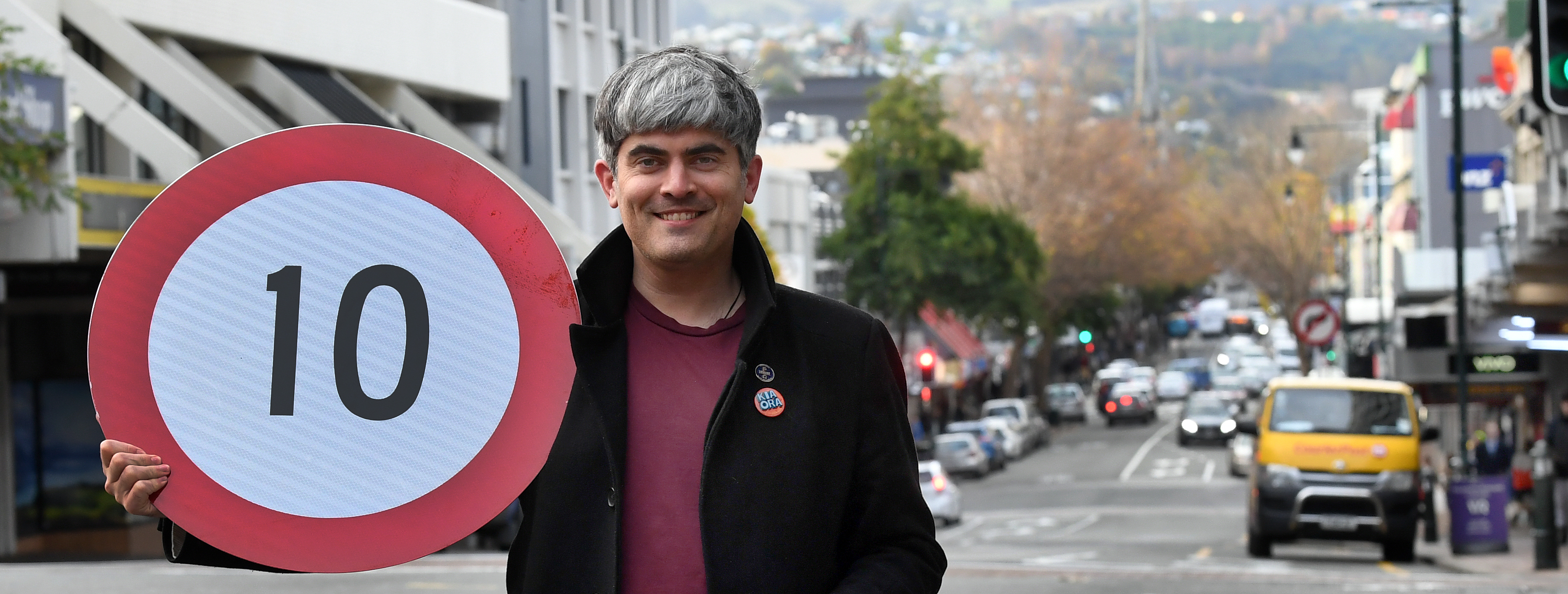 Dunedin Mayor Aaron Hawkins holds a new speed limit sign for George St as he celebrates the...