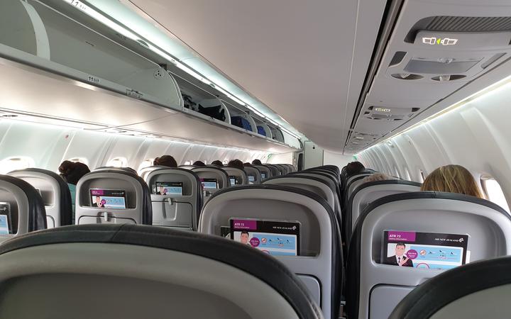 Passengers sitting at a distance from each other on an Air New Zealand flight from Christchurch...