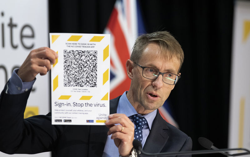 Dr Ashley Bloomfield holds up an example of a QR code that can be scanned by the recently...