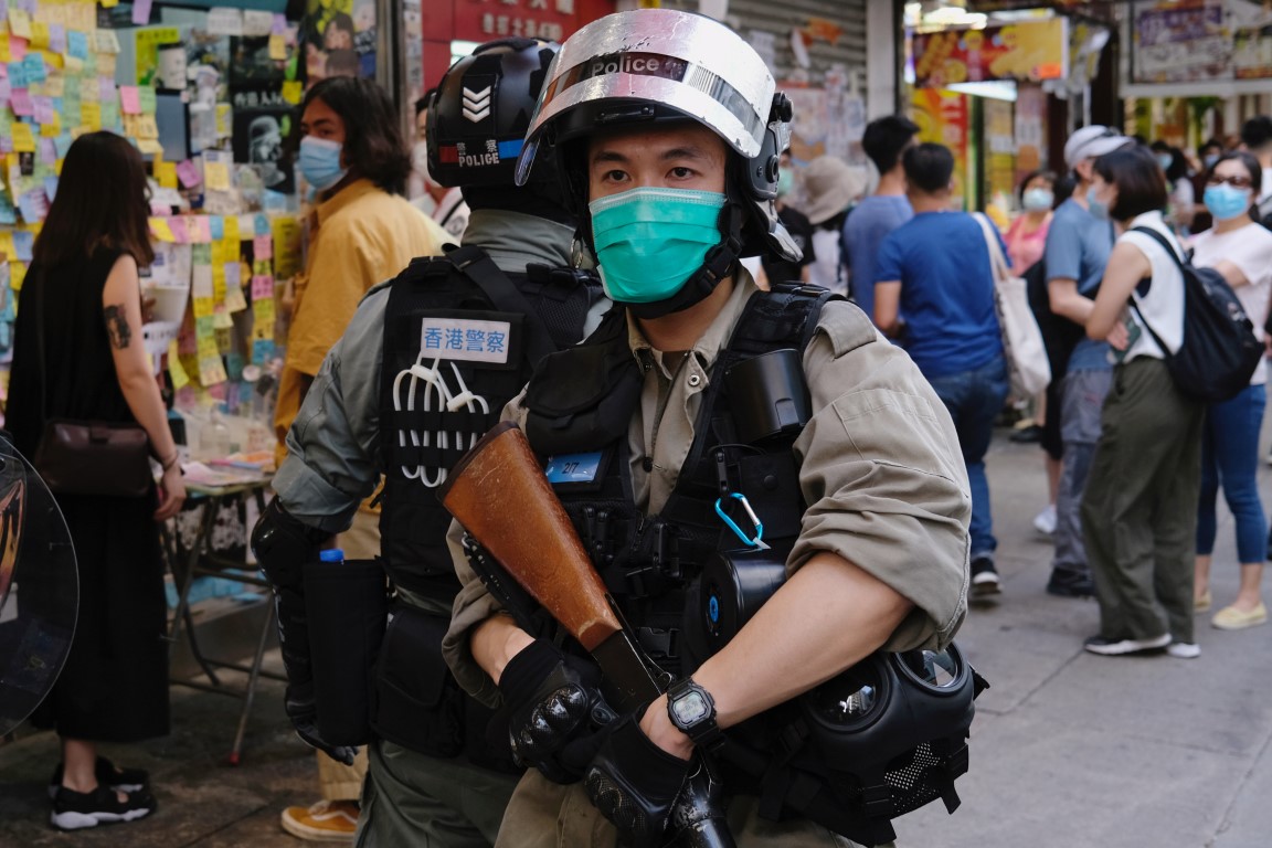 Riot police stand guard to avoid mass gathering during a protest against the looming national...