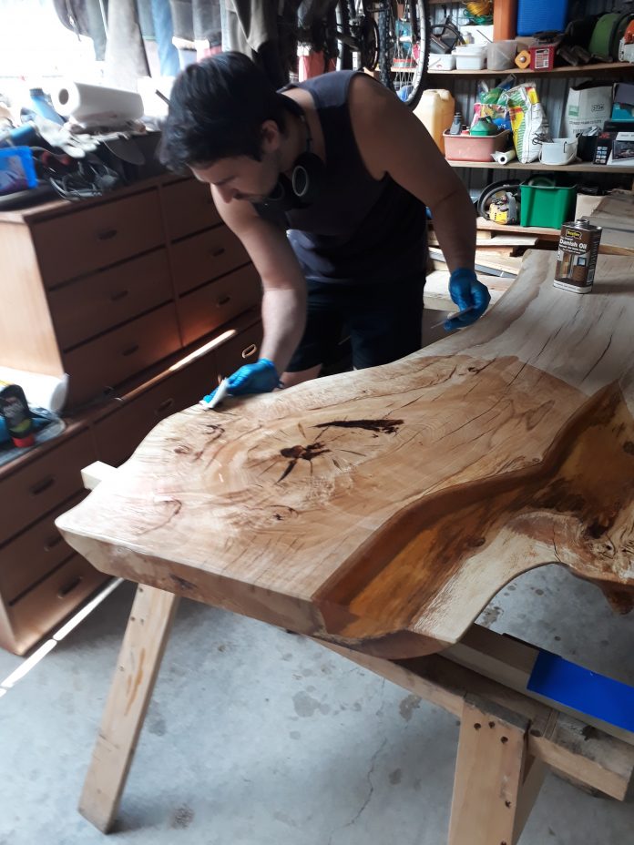 Nick Gyde stains his oak table. Photos: Supplied