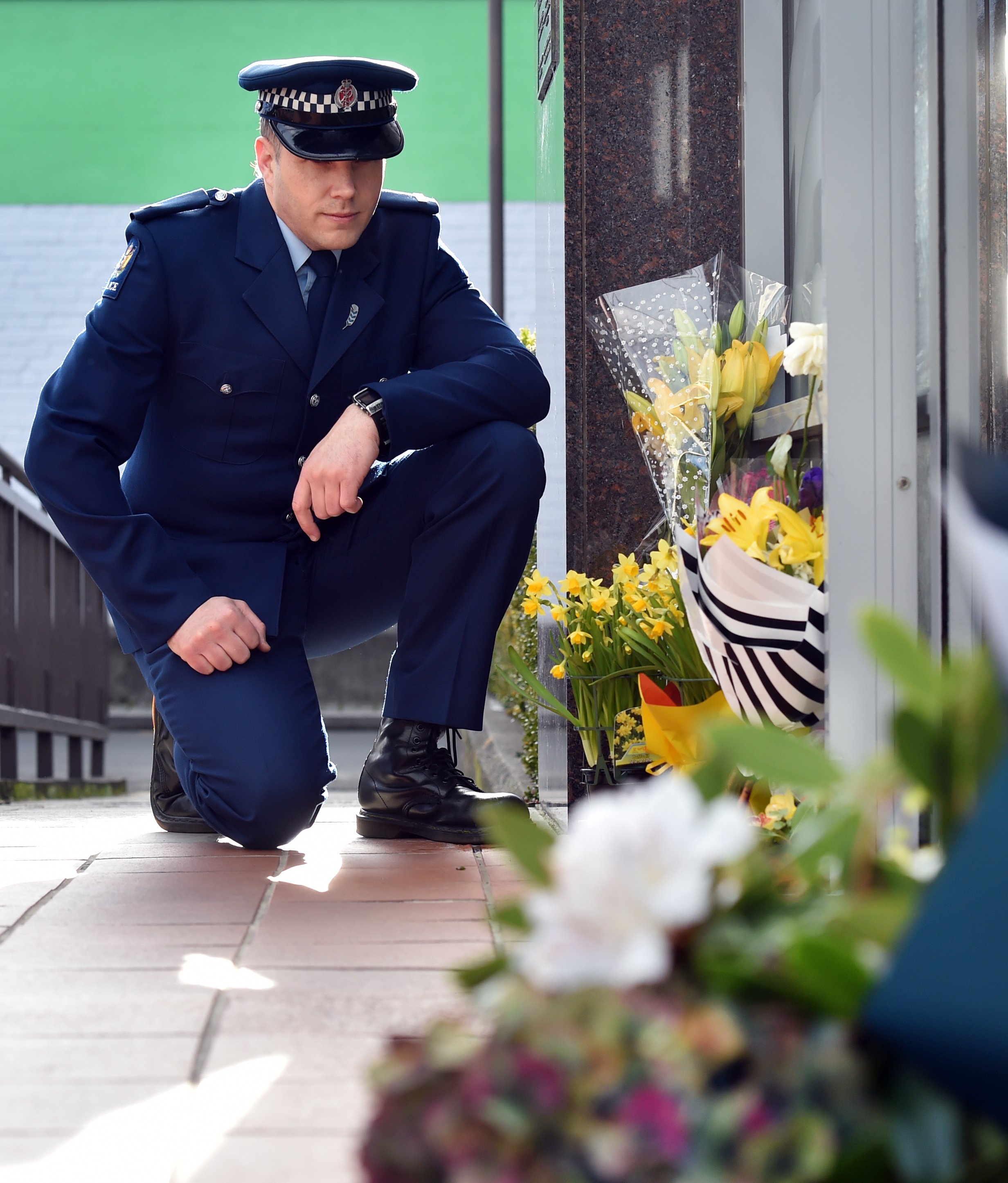 Constable Seaton McGuigan kneels at the entrance to the Dunedin police station to remember...