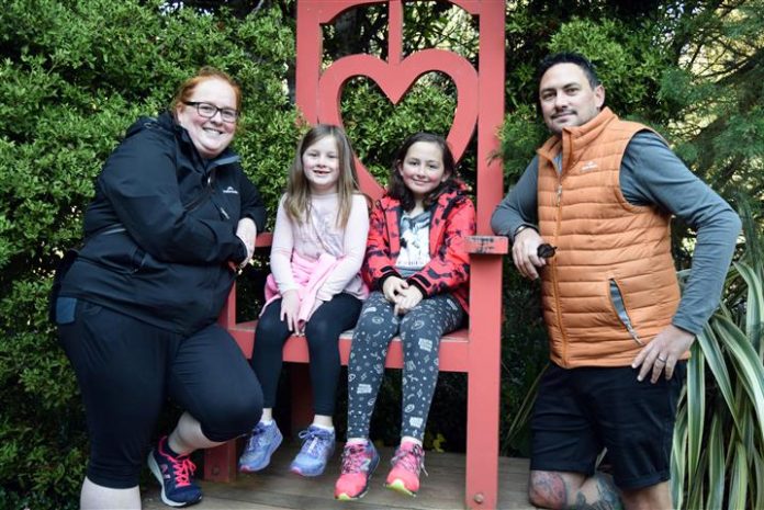 Enjoying a stop at the Queen of Hearts chair in the Larnach Castle garden are (from left) Harriet...