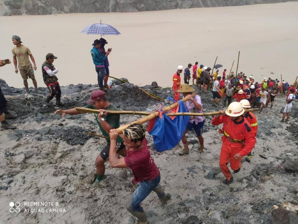Rescuers carry a body following the landslide at a mining site in Hpakant, Kachin State City,...