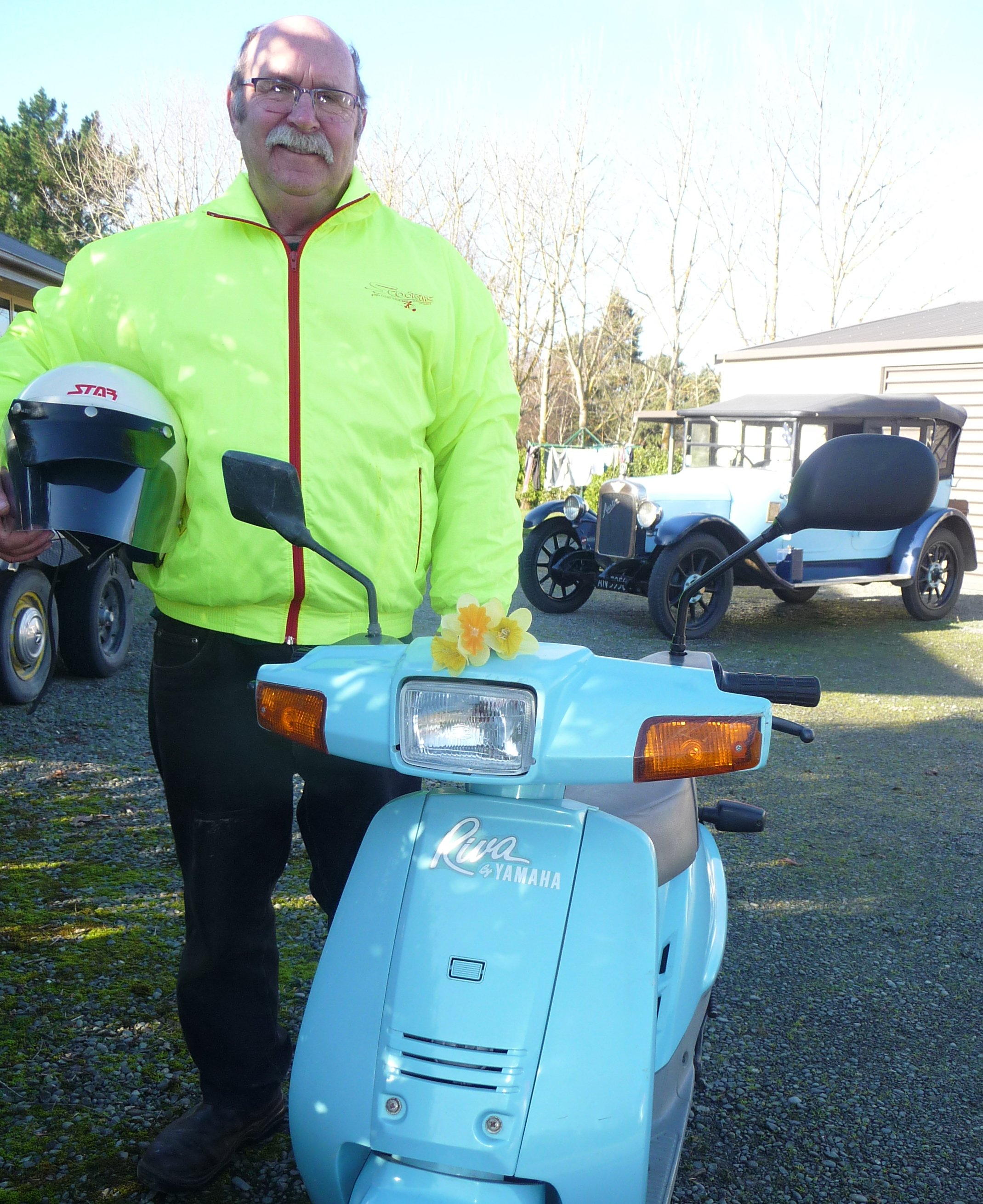 David Oakley with his 49cc Yamaha Riva Razz and in the back ground his 1926 Austin 12. Photo:...