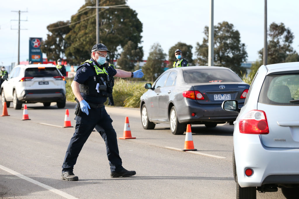 A police officer directs traffic into a checkpoint lane in Melbourne. Photo: Getty