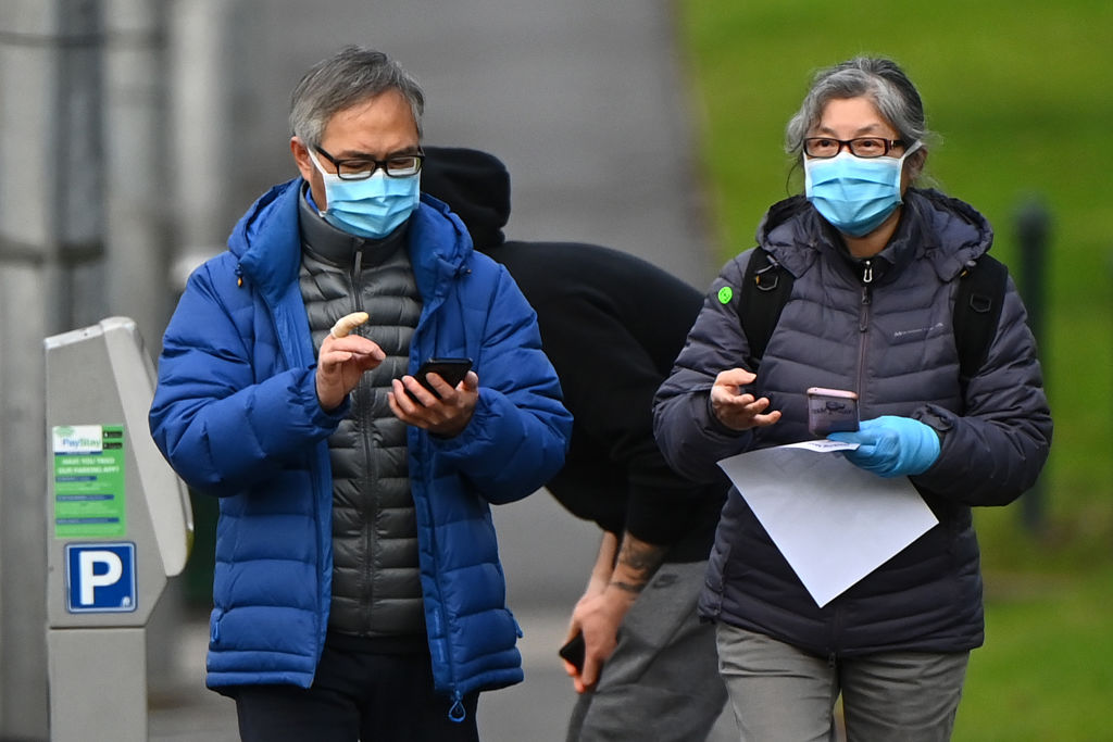 People in face masks on a city street in Melbourne. Masks or coverings will be mandatory for many...