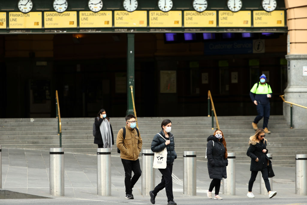 Mask-wearing people in front of Flinders Street Station in Melbourne earlier today. Photo: Getty