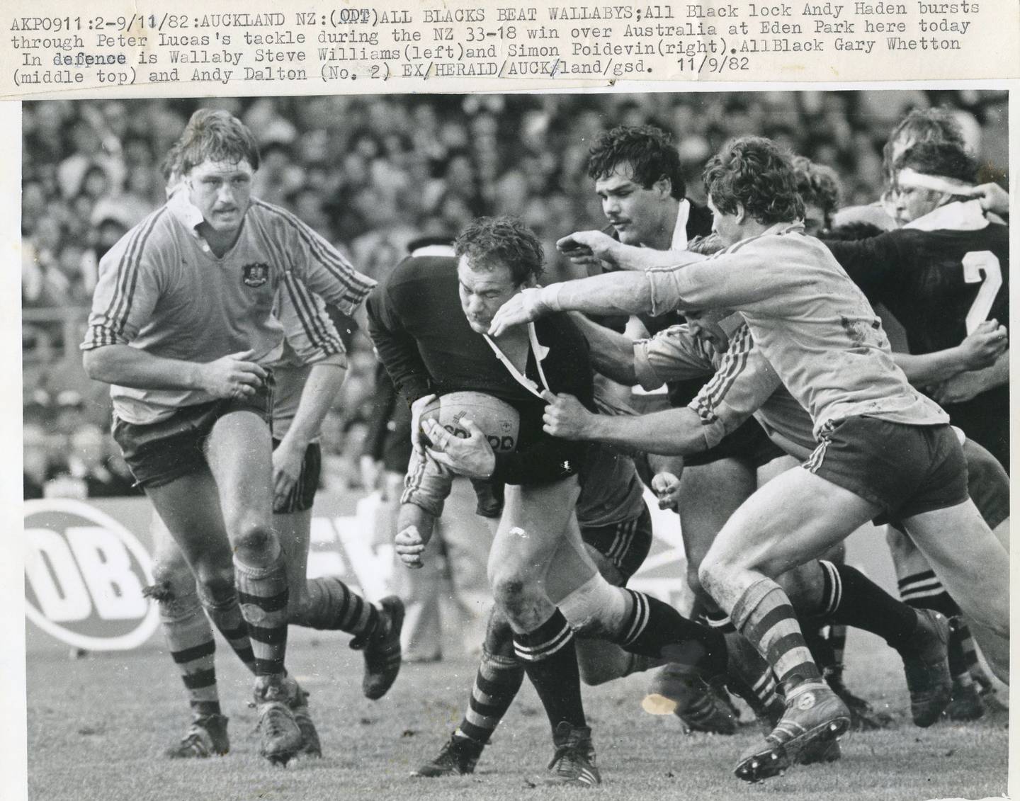 All Black lock Andy Haden bursts through the tackle of Wallaby Peter Lucas against Australia in a...