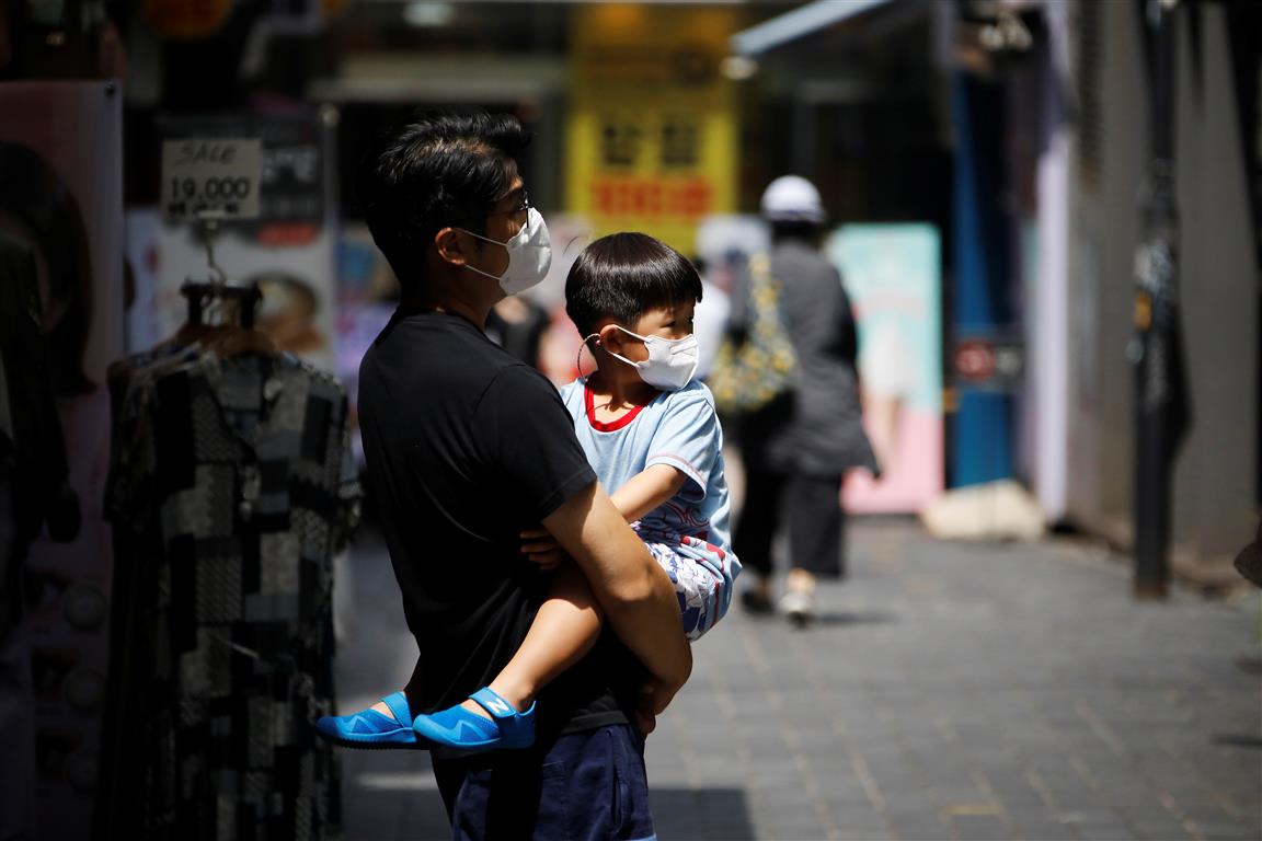 A man holds his son as they shop in the Myeongdong shopping district in Seoul. Photo: Reuters

