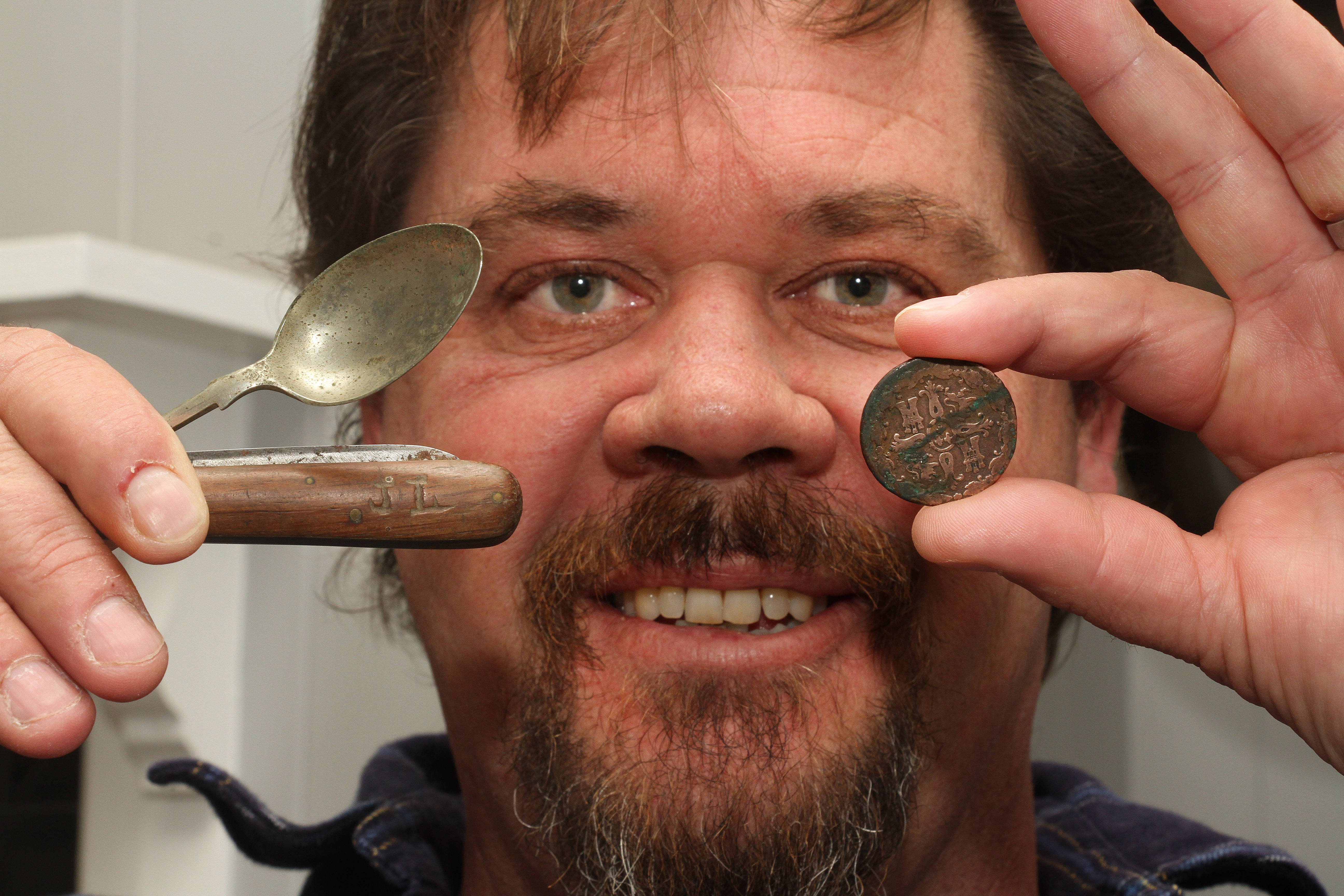 Builder Glenn Henderson presents the centuries-old discoveries at a cottage in Lawrence — a spoon, an engraved knife and a coin. PHOTO: JOHN COSGROVE