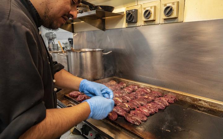 Assistant chef Alex Mahral cooks pūkeko on the hotplate. Photo: Fish & Game New Zealand