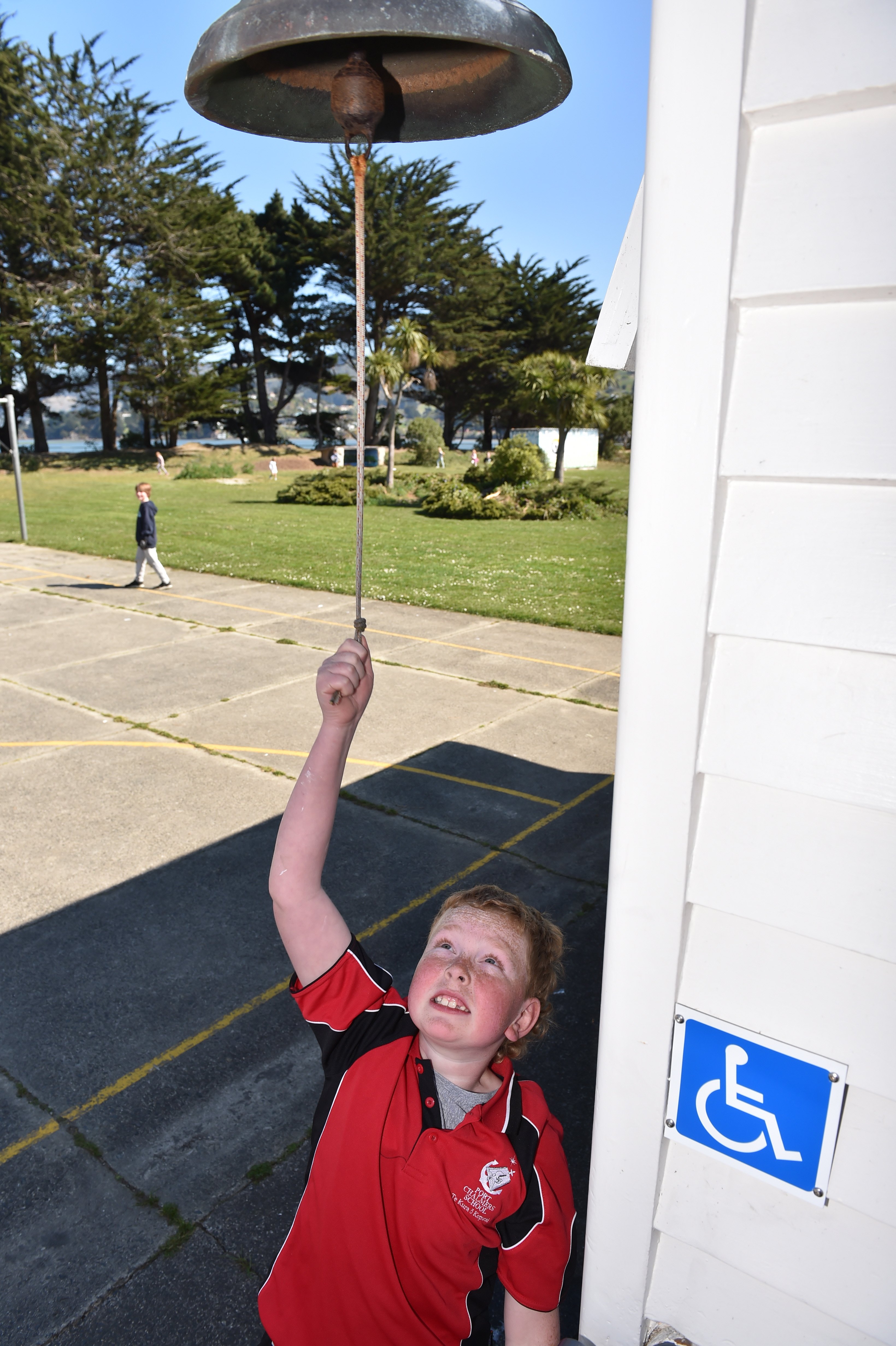 Port Chalmers School pupil Jimmy Hill (9) rings the school bell at 1pm yesterday to herald the...