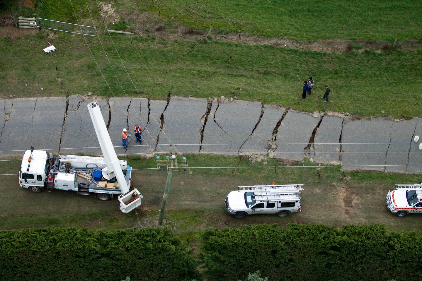Insurance and demolition workers watch as the earthquake-damaged building on the corner of...