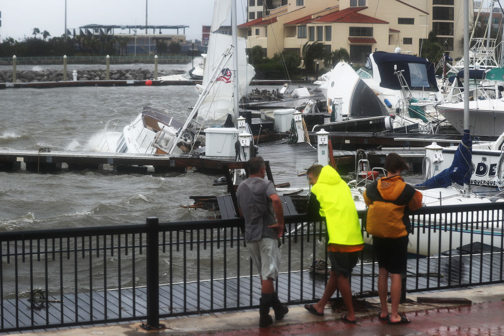 People look at damaged boats in the Palafox Pier Yacht marina after Hurricane Sally passed...