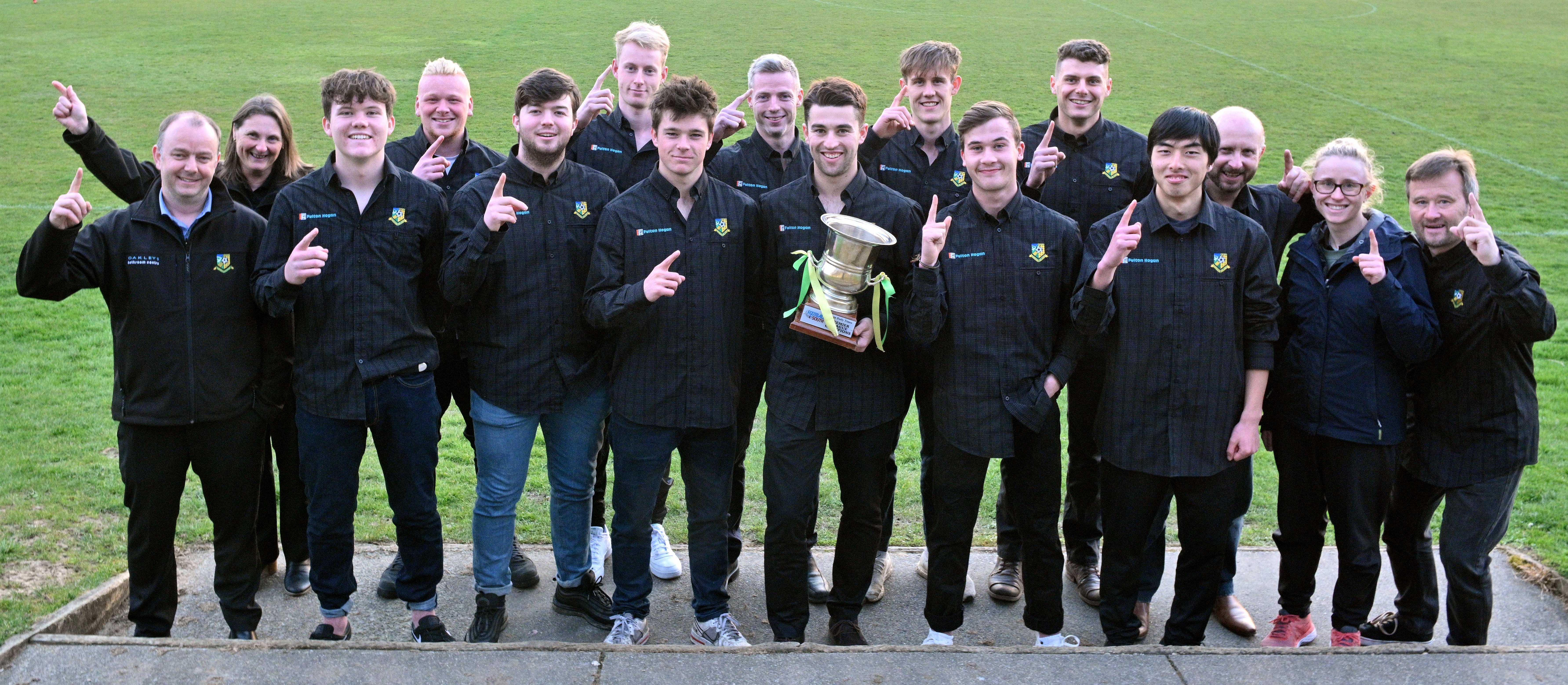 The Southern Premier League champion Green Island football team gathers with the trophy before...